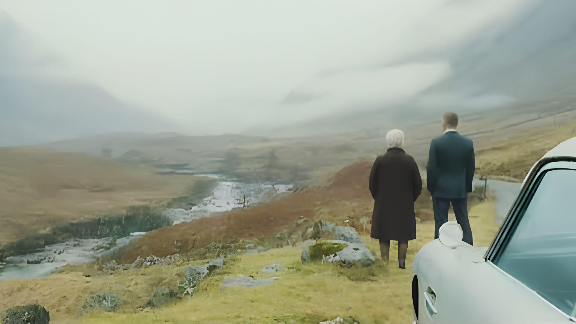 Bond and M overlooking misty Scottish valley from Skyfall Lodge