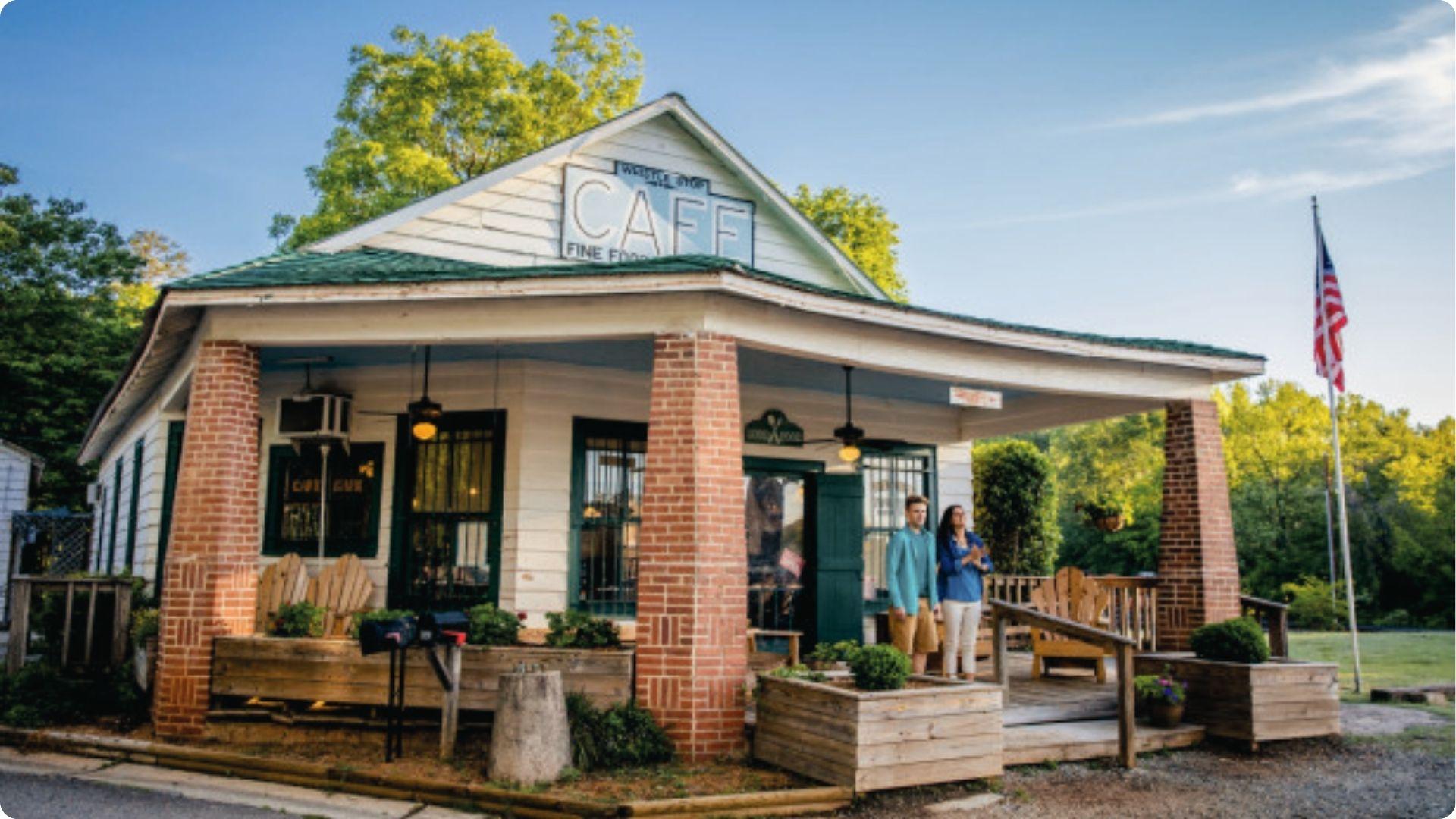 Whistle Stop Cafe exterior with American flag, porch.