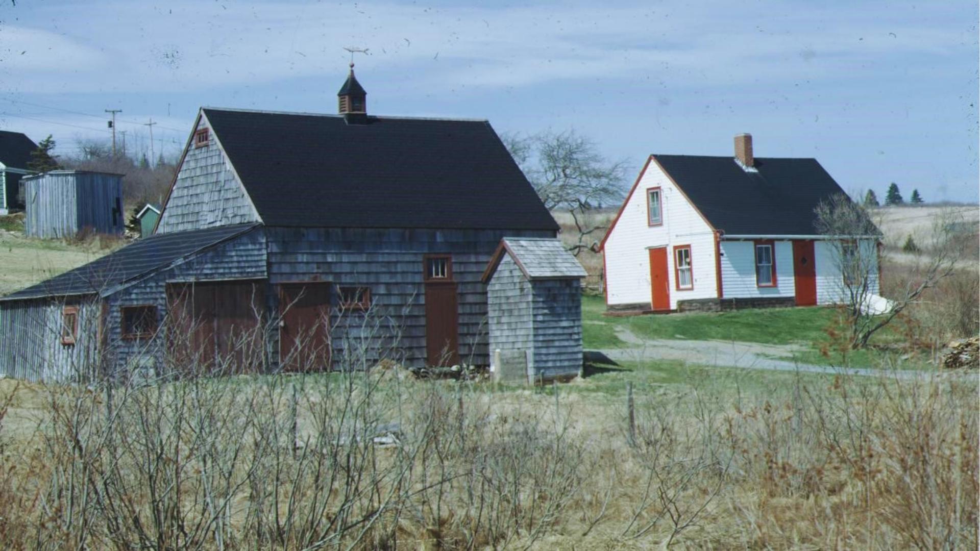 Rustic barn and white farmhouse with red doors in Nova Scotia, filming location used for We Were Liars scenes.