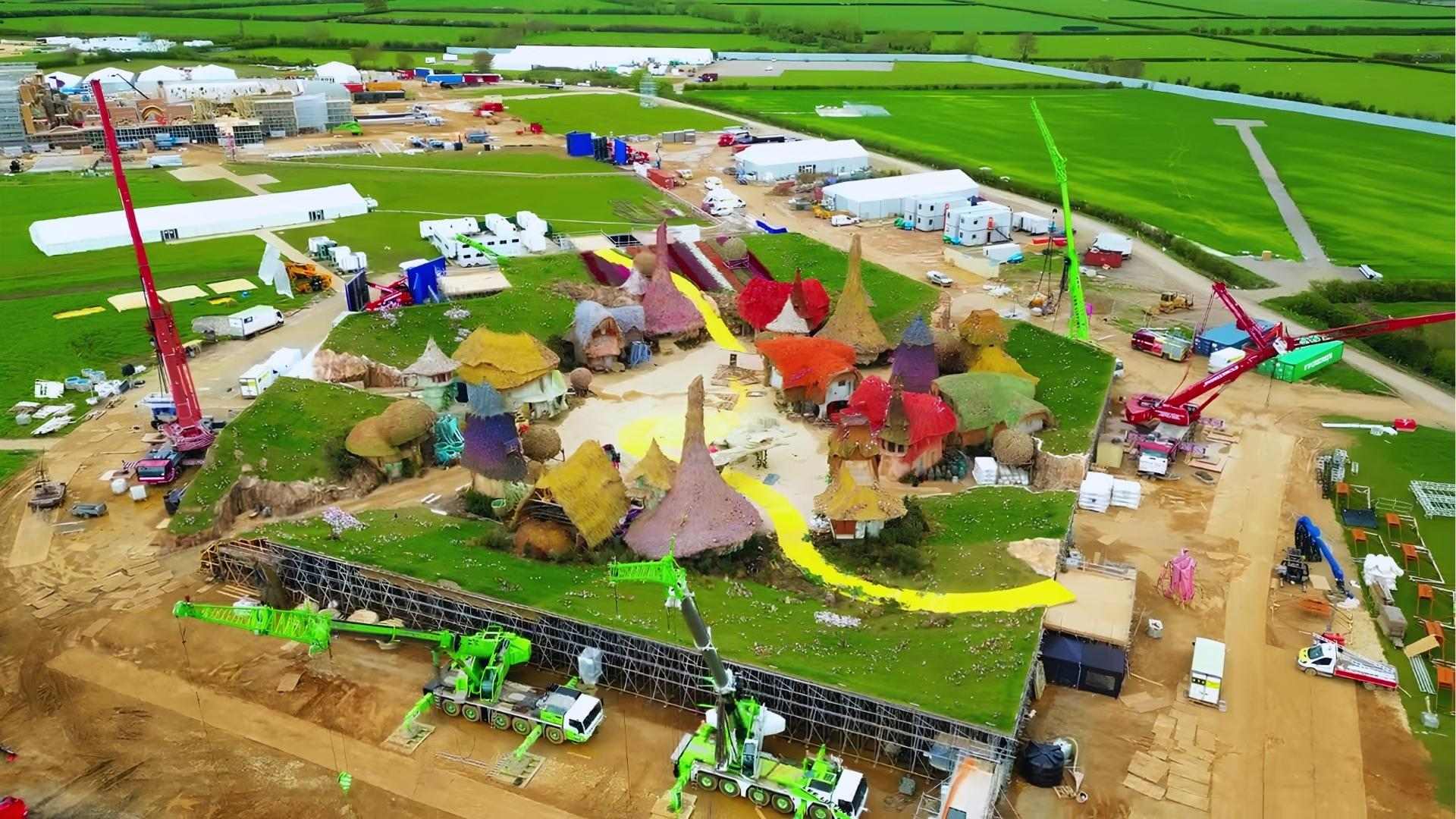 Aerial view of Munchkinland set with colorful houses and Yellow Brick Road at Sky Studios Elstree for Wicked.