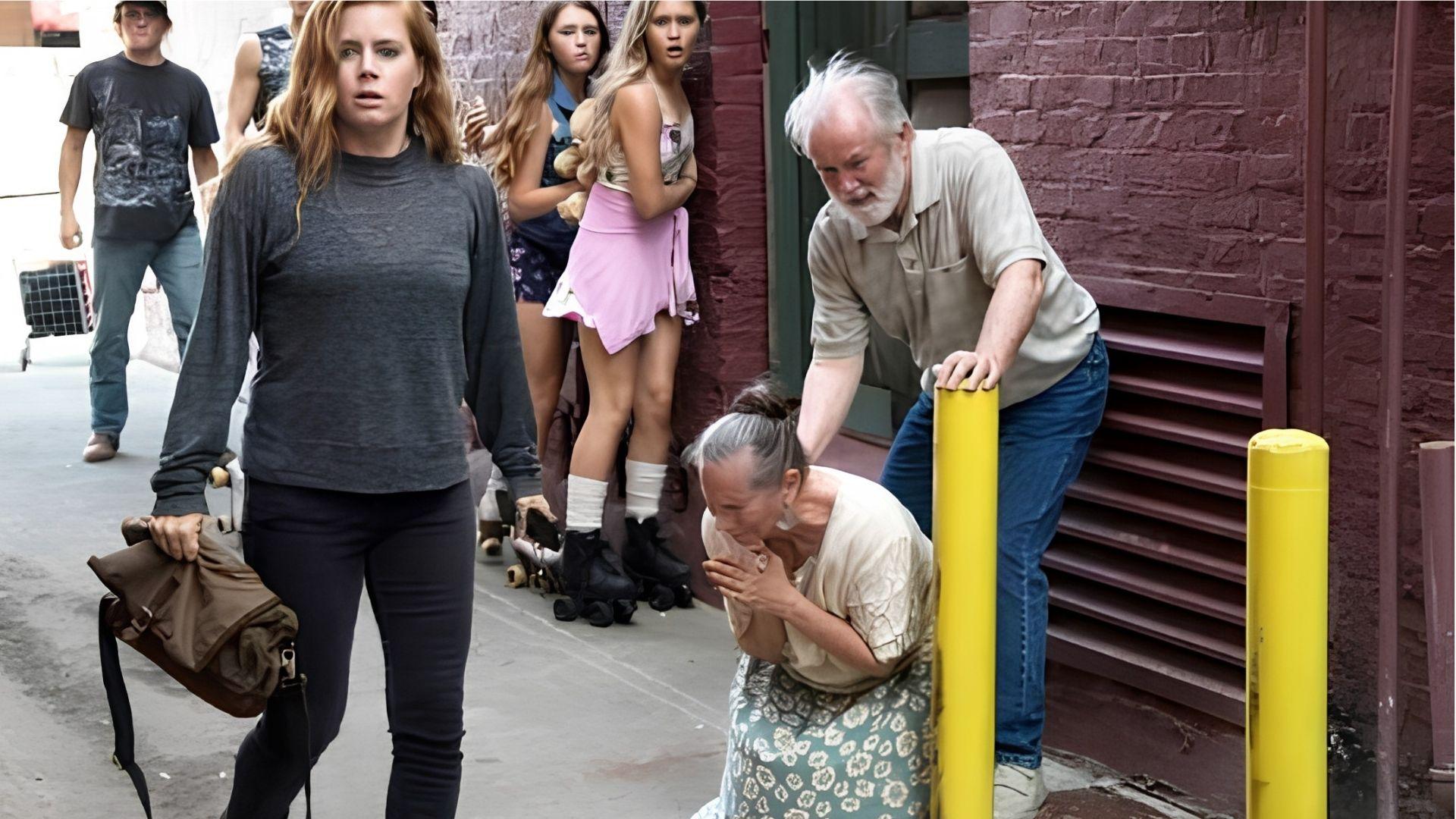 Amy Adams as Camille Preaker walks past Wind Gap locals in Sharp Objects