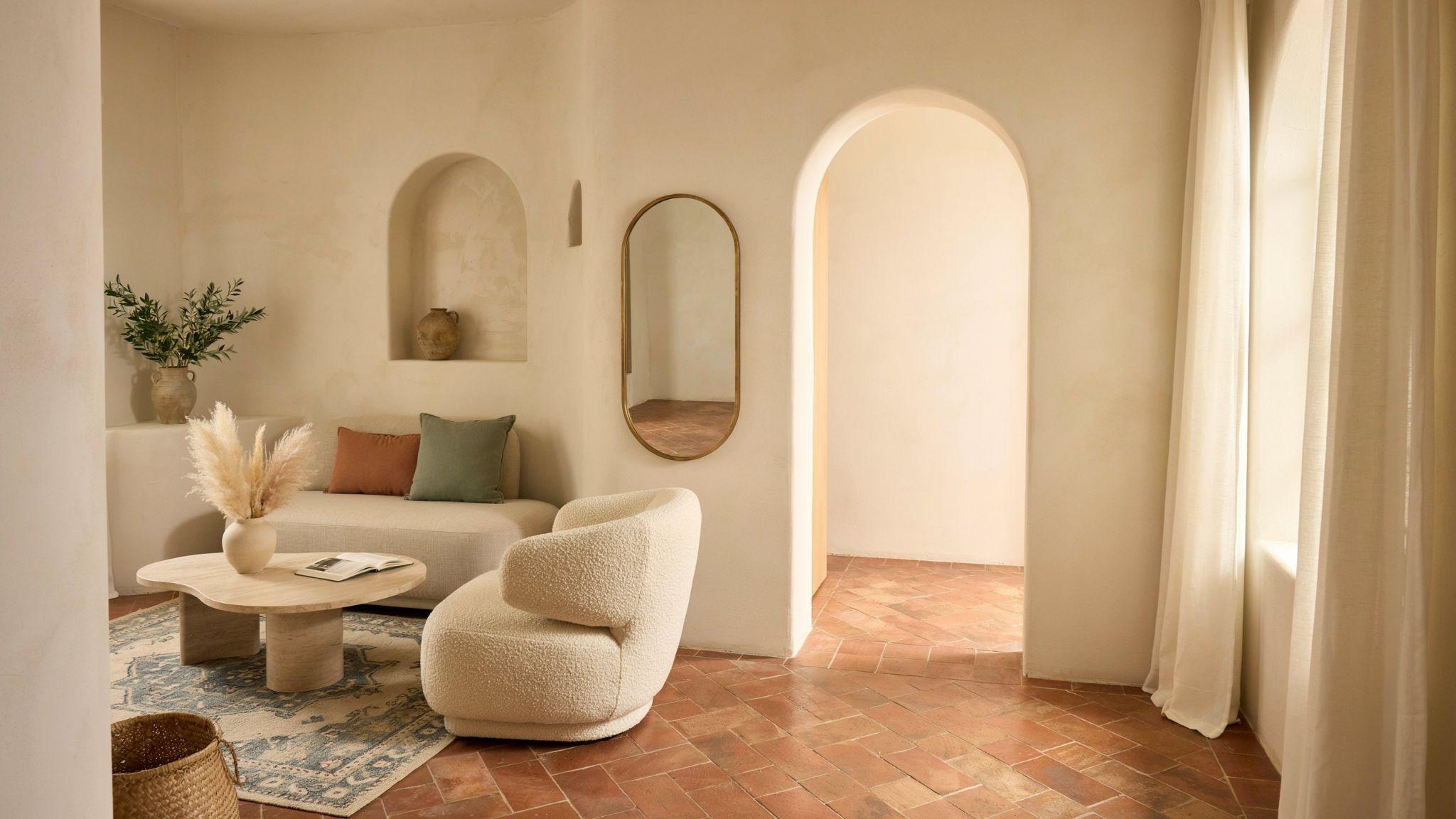 Mediterranean interior with arched doorways and curved furniture in a soft elegant space.