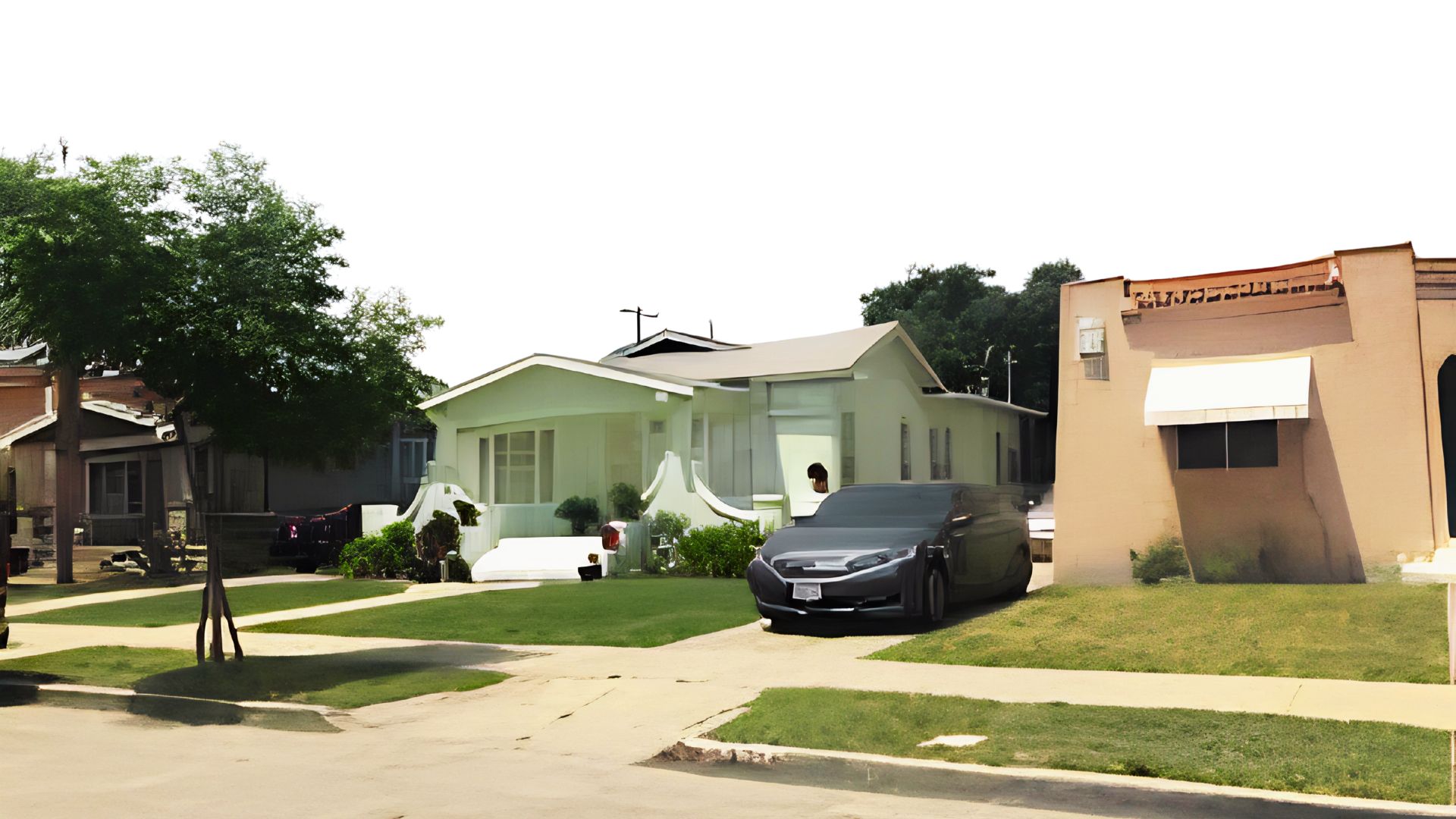 Light green craftsman bungalow with curved porch steps and a dark sedan parked in the driveway on a sunny day.