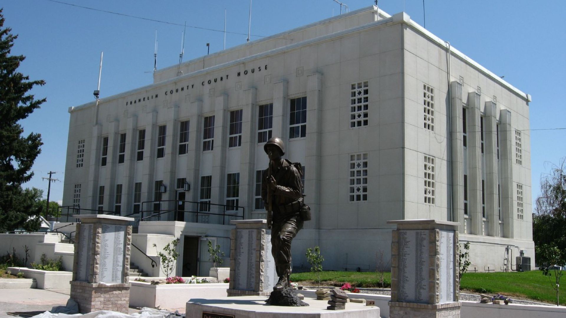 A statue depicting a man is positioned in front of a building, representing Preston, Idaho's cultural heritage and filming appeal.