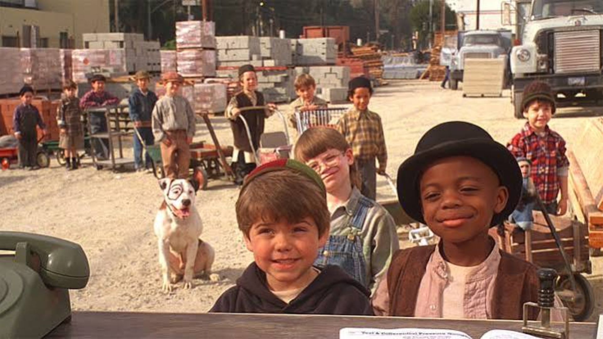 Little Rascals 1994 cast including Spanky and Buckwheat standing at an outdoor construction lot with their dog Pete