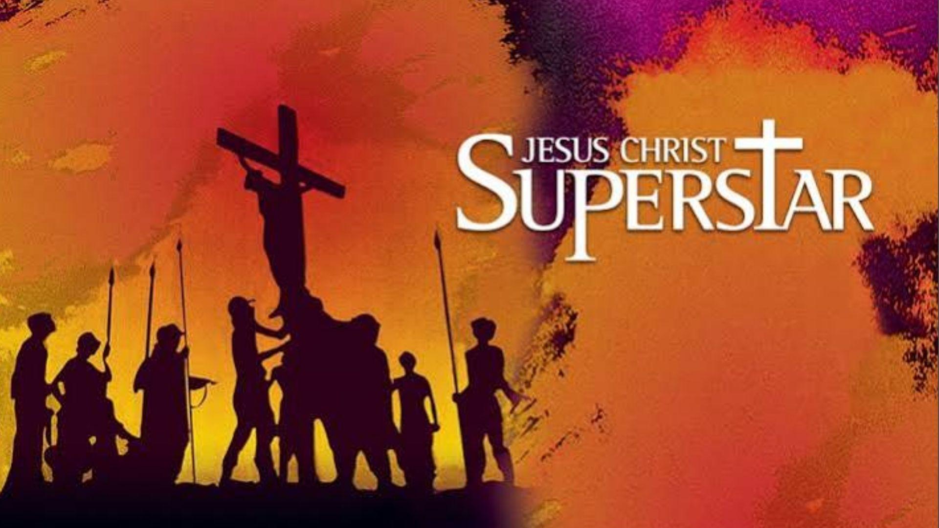Silhouette of crucifixion scene on orange background with Jesus Christ Superstar movie poster