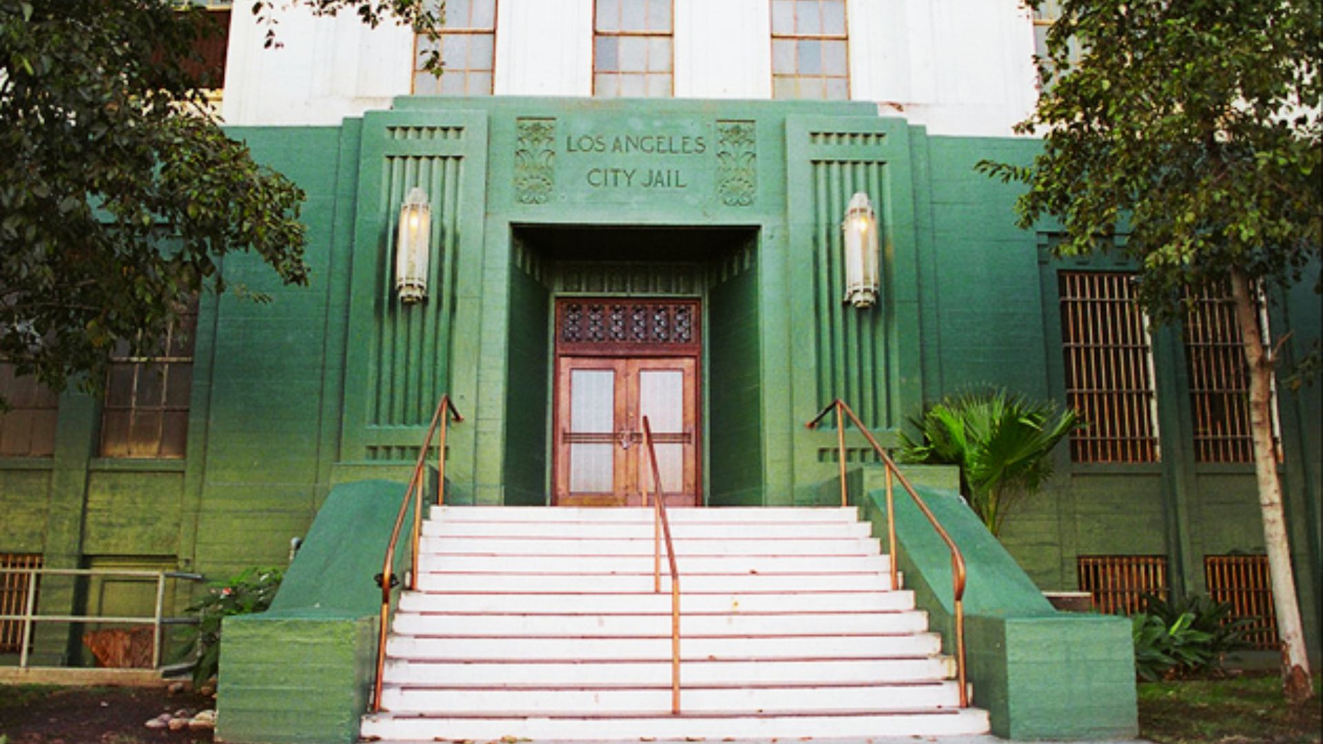 Art deco green facade with Los Angeles City Jail engraved above white stairs and double doors.